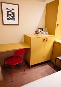 a small room with a desk and a red chair at The Times Hotel in Amsterdam
