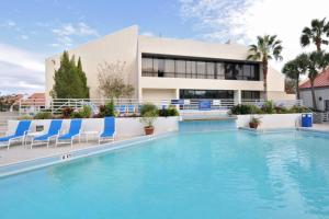 una piscina con sillas azules y un edificio en Gulf View from the Summit at Tops'l Beach Resort en Destin