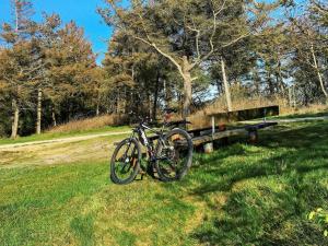 a bike parked in the grass next to a bench at 6 person holiday home in Hemmet in Hemmet