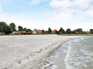 a view of the beach with houses in the background at 4 person holiday home in Bandholm in Bandholm