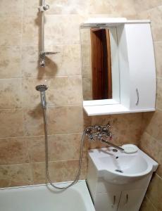 La salle de bains est pourvue d'une douche, d'un lavabo et d'un miroir. dans l'établissement Сонячна, à Trouskavets