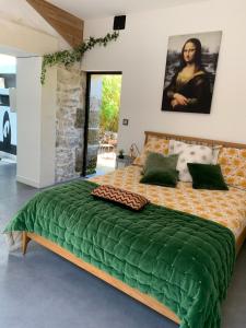 1 dormitorio con 1 cama grande y edredón verde en Le Jardin de LaCoste, en Narbona