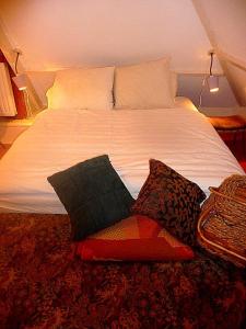 a white bed with pillows on top of it at Villa Zomerdijk in Velsen-Zuid