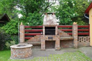 una chimenea de ladrillo frente a una valla roja en Aranyhal Apartman, en Hévíz