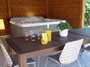 een tafel met wijnglazen en een hot tub bij Melody Huis in Poroszló