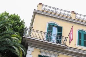 een gebouw met twee vlaggen op een balkon bij Hotel Latinum in Rome