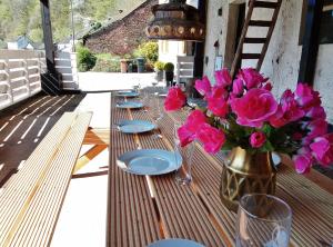 a wooden table with a vase of pink flowers on it at die rote Ente in Mürlenbach