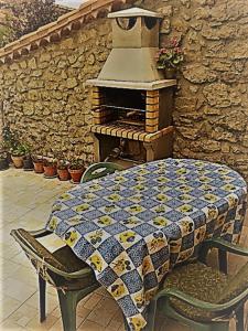 uma mesa com uma colcha ao lado de um forno de tijolos em Casa rural 47, La Acebosa, San Vicente de la Barquera em La Acebosa