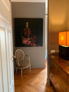 ein Bild einer Frau, die an einer Wand neben einem Stuhl sitzt in der Unterkunft Pattini Guest House in Mailand