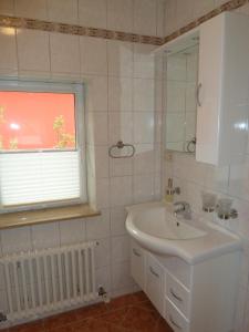 ein Bad mit einem Waschbecken, einem Spiegel und einem Fenster in der Unterkunft Ferien auf Rügen Familie Geist in Garz