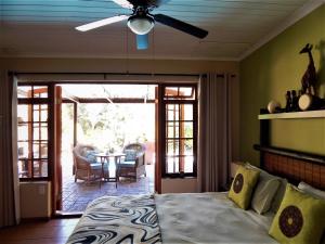 a bedroom with a bed and a patio with a table at Khashamongo B & B in Somerset West +104 photos