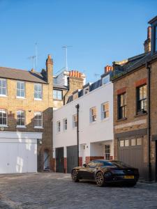 a black car parked in a parking lot in front of buildings at Weymouth Mews in London