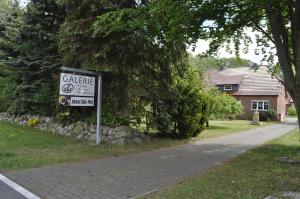 a sign on the side of a road next to a house at Galerie ebe in Parchim