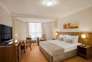 a hotel room with a bed and a table and chairs at Windsor Plaza Brasilia in Brasilia