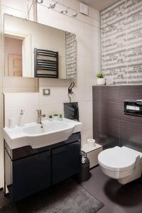 a bathroom with a white sink and a toilet at Movie Apartment Jeżyce in Poznań