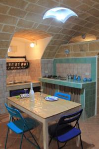 a kitchen with a table with blue chairs and a counter at Bilocale Dillo alla luna in Gallipoli +20 photos