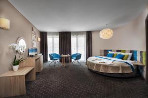 een hotelkamer met een bed en een tafel en stoelen bij Hotel Szafir in Jastrzębia Góra