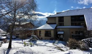 une maison avec des animaux debout dans la neige dans l'établissement Le Catinat Fleuri, à Guillestre