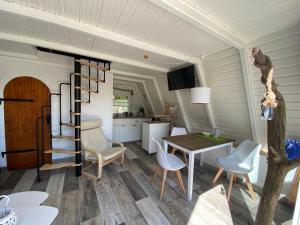 eine Küche und ein Esszimmer mit einer Wendeltreppe in einem winzigen Haus in der Unterkunft Ferienhaus nähe Warnemünde 3 in Elmenhorst