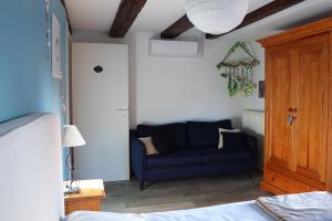 a living room with a blue couch in a room at Sous les toits du Zinc - Climatisé in Colmar