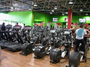 un gimnasio con un montón de máquinas de correr en una habitación en Hotel Galaico en Collado-Villalba