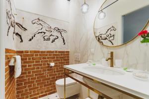 a bathroom with a white sink and a mirror at Apartamenty Bracka 6 in Kraków