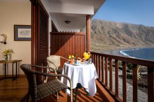 a table on a balcony with a view of the ocean at Parador de El Hierro in Las Casas