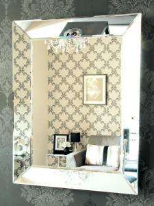 uno specchio in una stanza con un letto di Harrogate Boutique Apartments - Self Contained Apartments a Harrogate