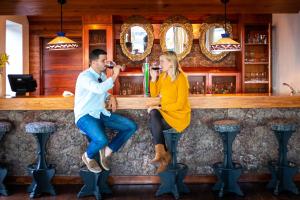 a man and woman drinking wine at a bar at Parador de El Hierro in Las Casas