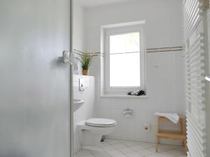 アールベックにあるFerienwohnung 1 05 Inselstrandの白いバスルーム(トイレ、窓付)