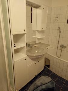 a white bathroom with a sink and a shower at Ferienhaus Raumberg in Raumberg +9 photos