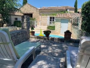 einen Garten mit zwei Gartenstühlen und einem Haus in der Unterkunft La Forge - Gordes in Gordes