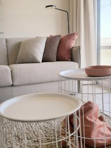 een woonkamer met 2 tafels en een bank bij Léonie met parking in Nieuwpoort