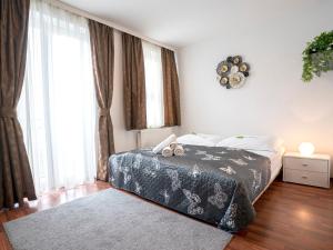 een slaapkamer met een bed in een kamer met ramen bij Apartments City Centre in Bratislava