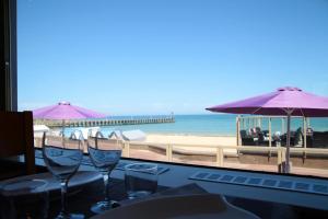 a table with wine glasses on the beach at Ryo Beach in Courseulles-sur-Mer +15 photos