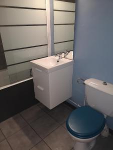 a bathroom with a sink and a toilet with a blue seat at Ryo Beach in Courseulles-sur-Mer