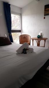 duże białe łóżko w pokoju z oknem w obiekcie Hotel Les Esseppes w mieście LʼÉpine