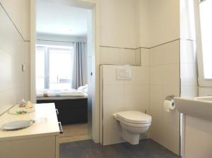 a white bathroom with a toilet and a sink at Erdgeschoss Wohnung Watt'n Meer mit Garten in Dangast in Varel