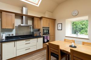 a kitchen with a wooden table and a dining room at Isle of Eriska Hotel Spa & Island in Benderloch