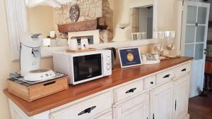 a counter with a microwave on top of it at Le Domaine de Bella in Dangé