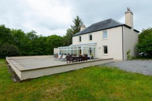 a large white house with a large wooden deck at Isle of Eriska Hotel Spa & Golf in Benderloch