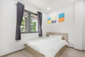 Postel nebo postele na pokoji v ubytování Dlux Saigon