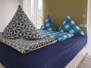 ein Bett mit blauen und weißen Kissen darauf in der Unterkunft Ferienwohnungen direkt am See in Mücheln
