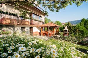 a house with a garden with flowers in front of it at Apartment Bon in Kobarid