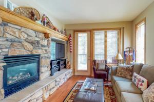 a living room with a large stone fireplace at Mammoth Green Condos in Mammoth Lakes