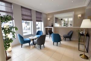 a waiting room with blue chairs and a table at Alyss Saphir Cambronne Eiffel in Paris