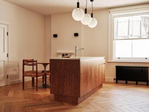 a kitchen with a sink and a table in a room at Weymouth Mews in London