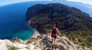 a man standing on top of a mountain overlooking the ocean at Samsara Beach in Port d'Alcudia