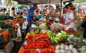 a group of people standing at a market with vegetables at Samsara Beach in Port d'Alcudia