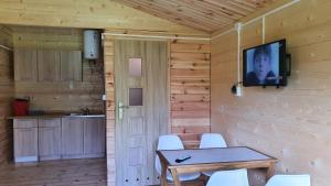 魯恰內尼達的住宿－Eco domki，一间设有桌子和墙上电视的用餐室